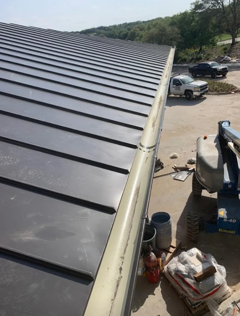 Standing seam panel and gutter detail on a metal roofing jobsite in Fairhaven